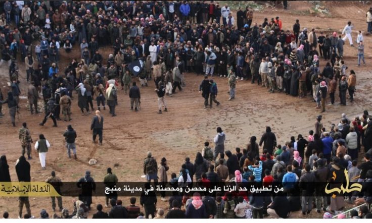 A crowd watch a man and a woman being stoned to death for adultery in Manbij, Syria
